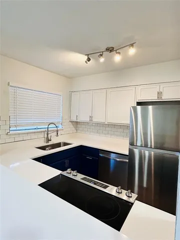 a kitchen with granite countertop a sink and stainless steel appliances