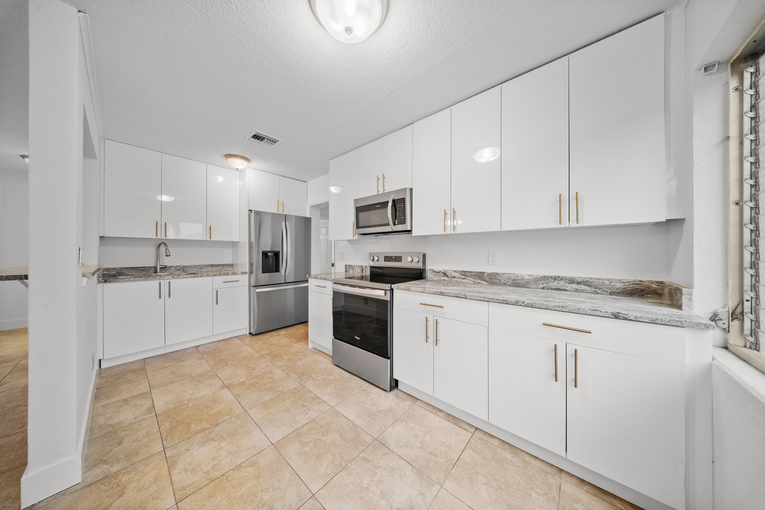 2904 Southeast Bamboo Street Stuart, FL 34997 - Photo 11 of 51 a kitchen with granite countertop white cabinets and white appliances