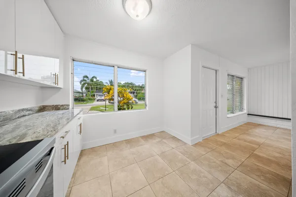 a view of kitchen with granite countertop cabinets and window
