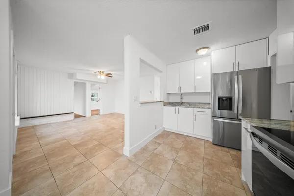 a kitchen with a refrigerator and a stove top oven