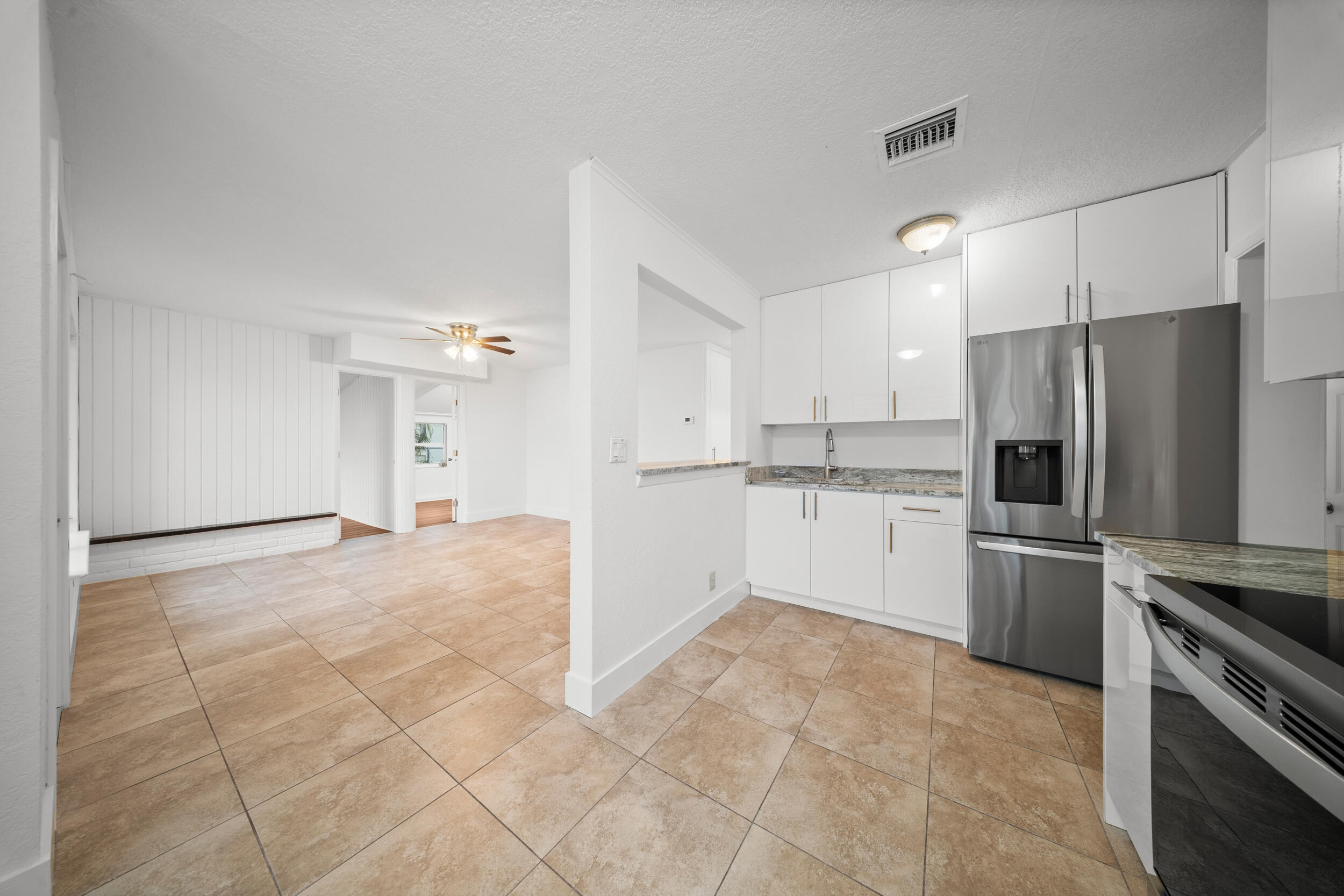 2904 Southeast Bamboo Street Stuart, FL 34997 - Photo 13 of 51 a kitchen with a refrigerator and a stove top oven