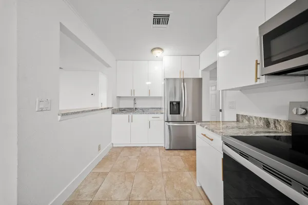 a kitchen with a sink stainless steel appliances and white cabinets