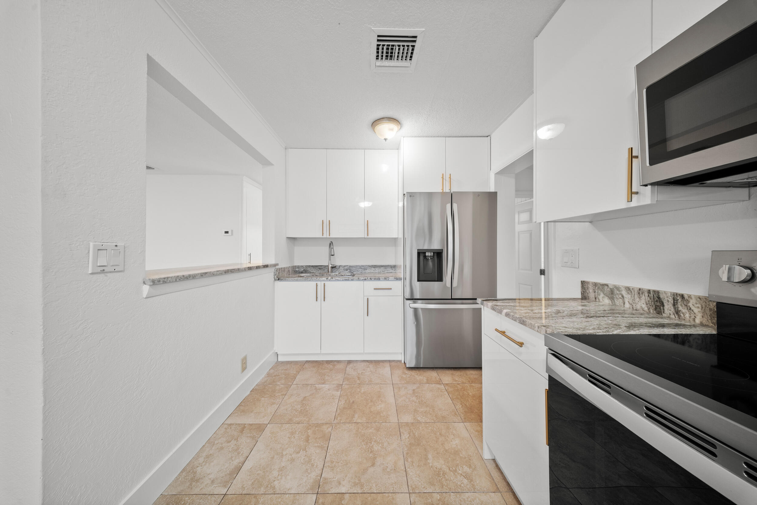2904 Southeast Bamboo Street Stuart, FL 34997 - Photo 14 of 51 a kitchen with a sink stainless steel appliances and white cabinets