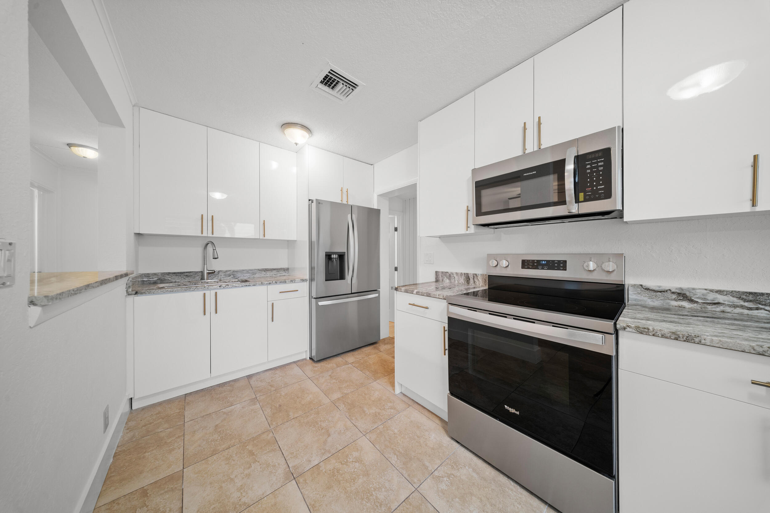 2904 Southeast Bamboo Street Stuart, FL 34997 - Photo 15 of 51 a kitchen with stainless steel appliances granite countertop a stove a sink and a microwave