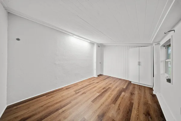 a view of empty room with wooden floor