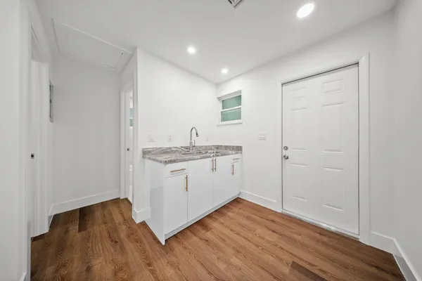 a kitchen with granite countertop white cabinets and white appliances