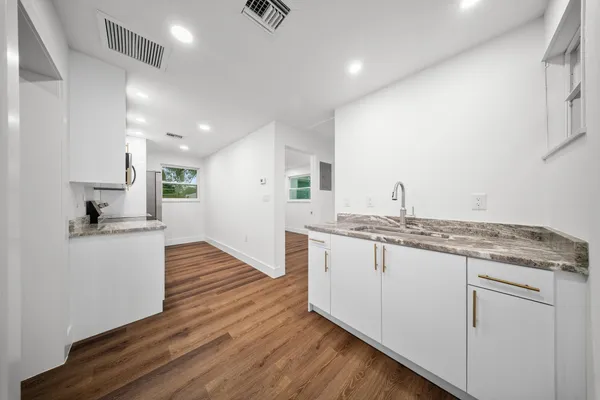 a view of a kitchen with sink and cabinets