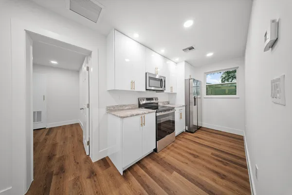a kitchen with stainless steel appliances granite countertop a stove a sink and a refrigerator