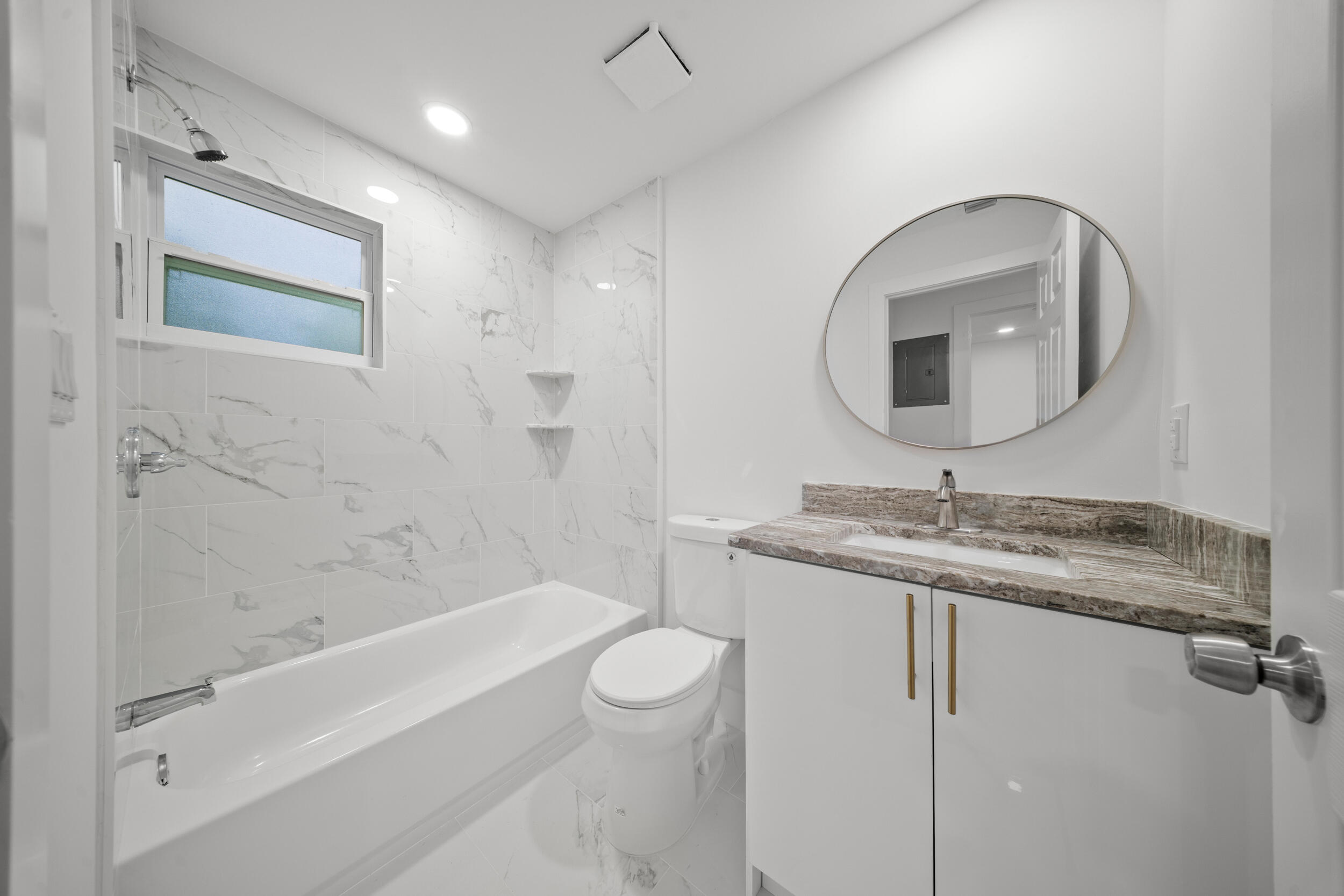 2904 Southeast Bamboo Street Stuart, FL 34997 - Photo 43 of 51 a bathroom with a granite countertop sink a toilet and a mirror