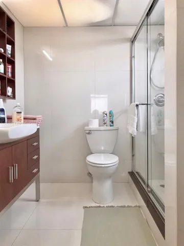 a bedroom with a white bed and a white cabinet