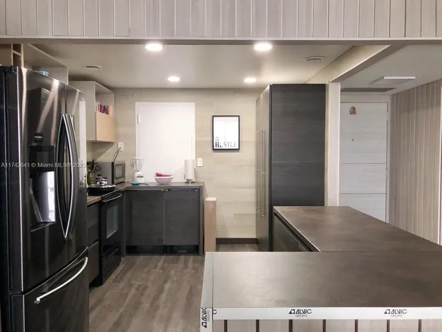 a kitchen with stainless steel appliances granite countertop a refrigerator and a sink