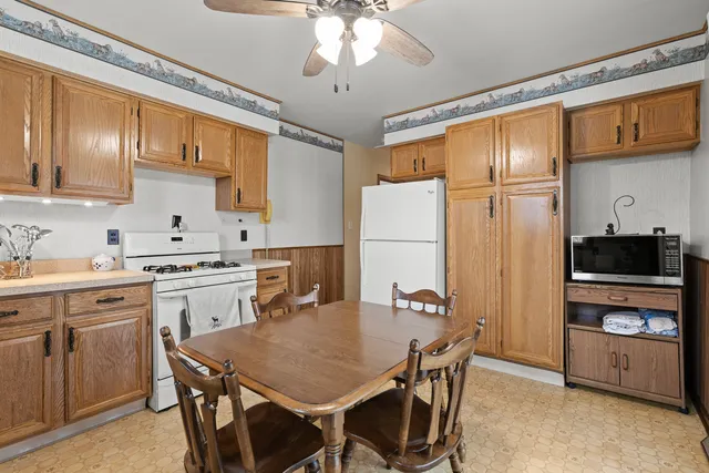 a kitchen with a table chairs refrigerator and cabinets