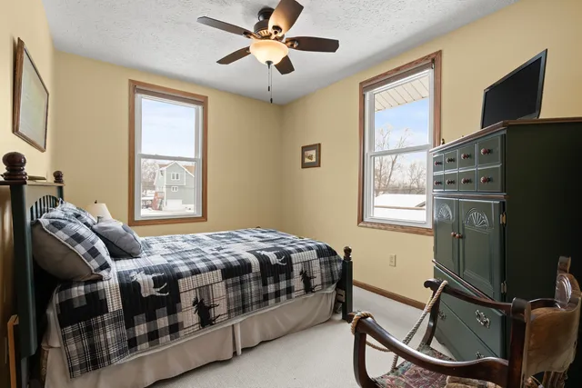 a bedroom with a bed chair and a window
