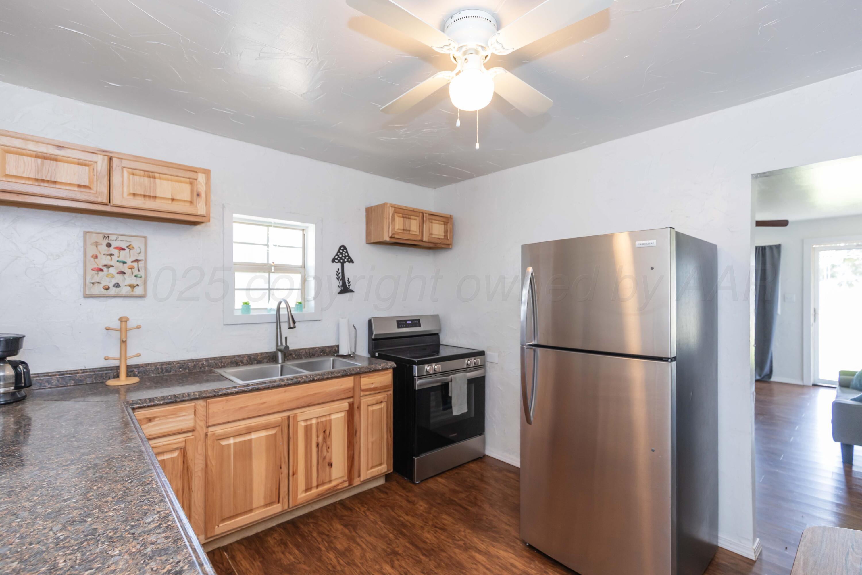 105 Poplar Street Skellytown, TX 79080 - Photo 14 of 37 a kitchen with stainless steel appliances granite countertop a refrigerator a stove a sink a microwave and island