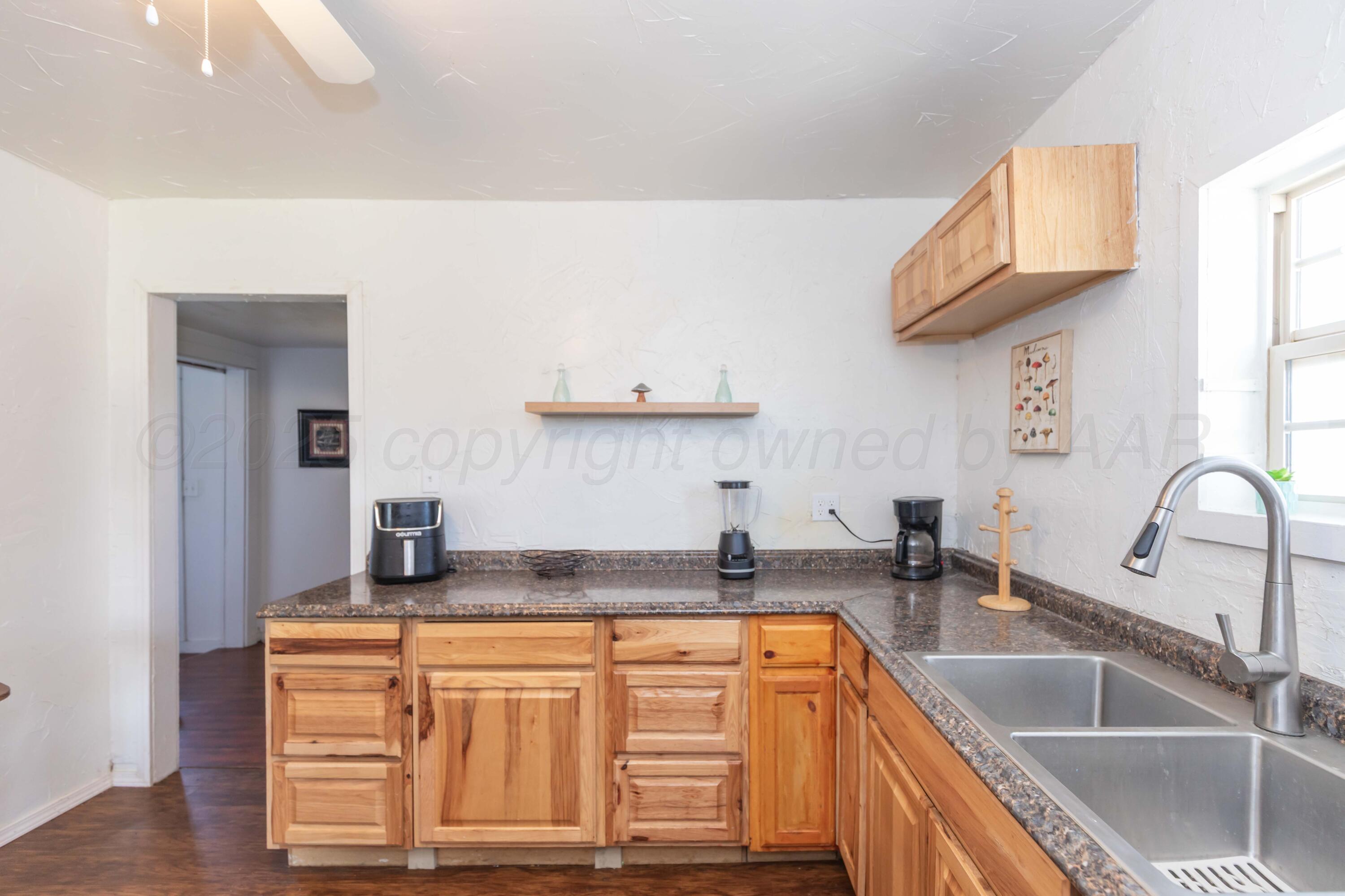 105 Poplar Street Skellytown, TX 79080 - Photo 15 of 37 a kitchen with granite countertop a sink a stove and cabinets
