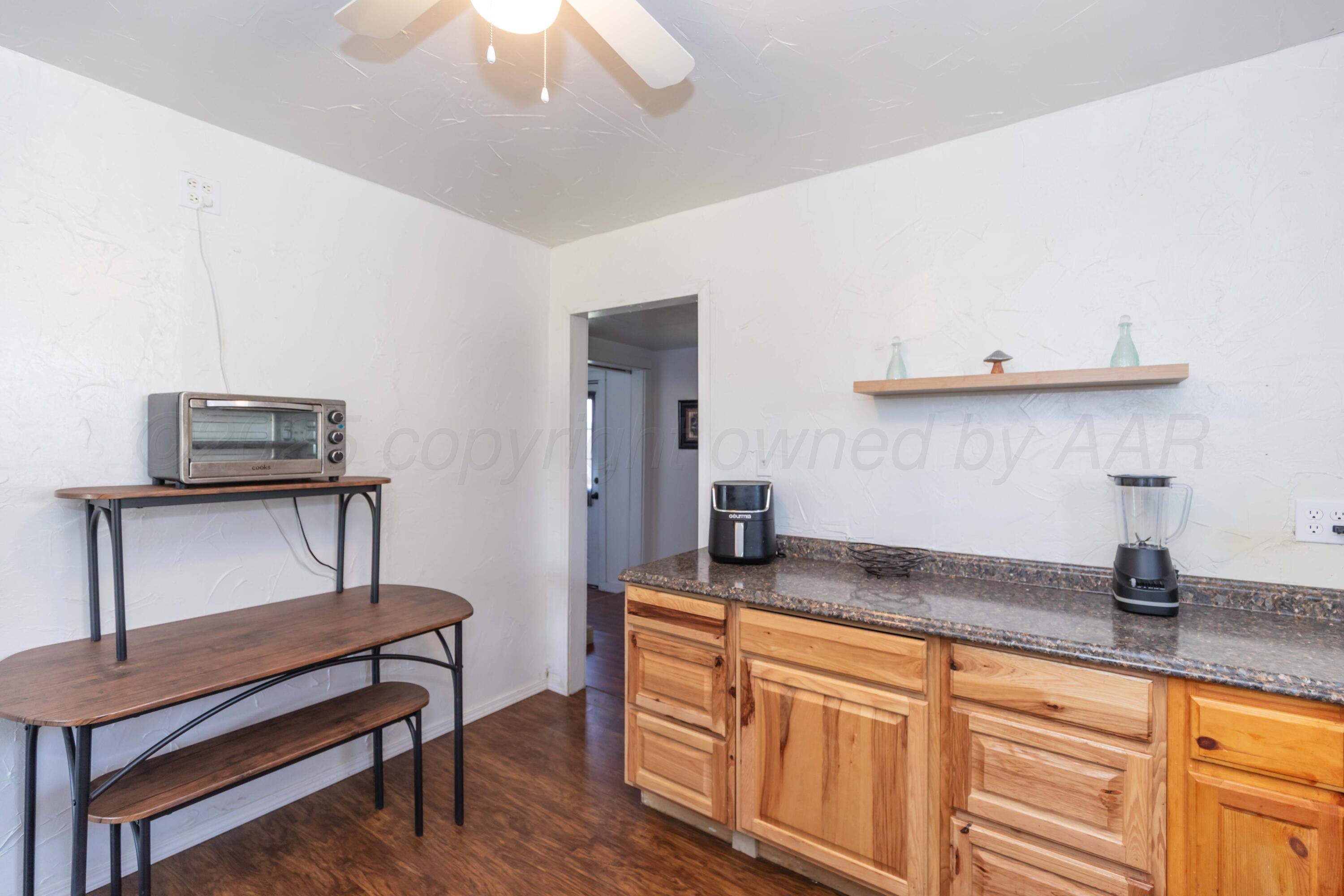 105 Poplar Street Skellytown, TX 79080 - Photo 16 of 37 a kitchen with granite countertop a sink a stove and a wooden floor