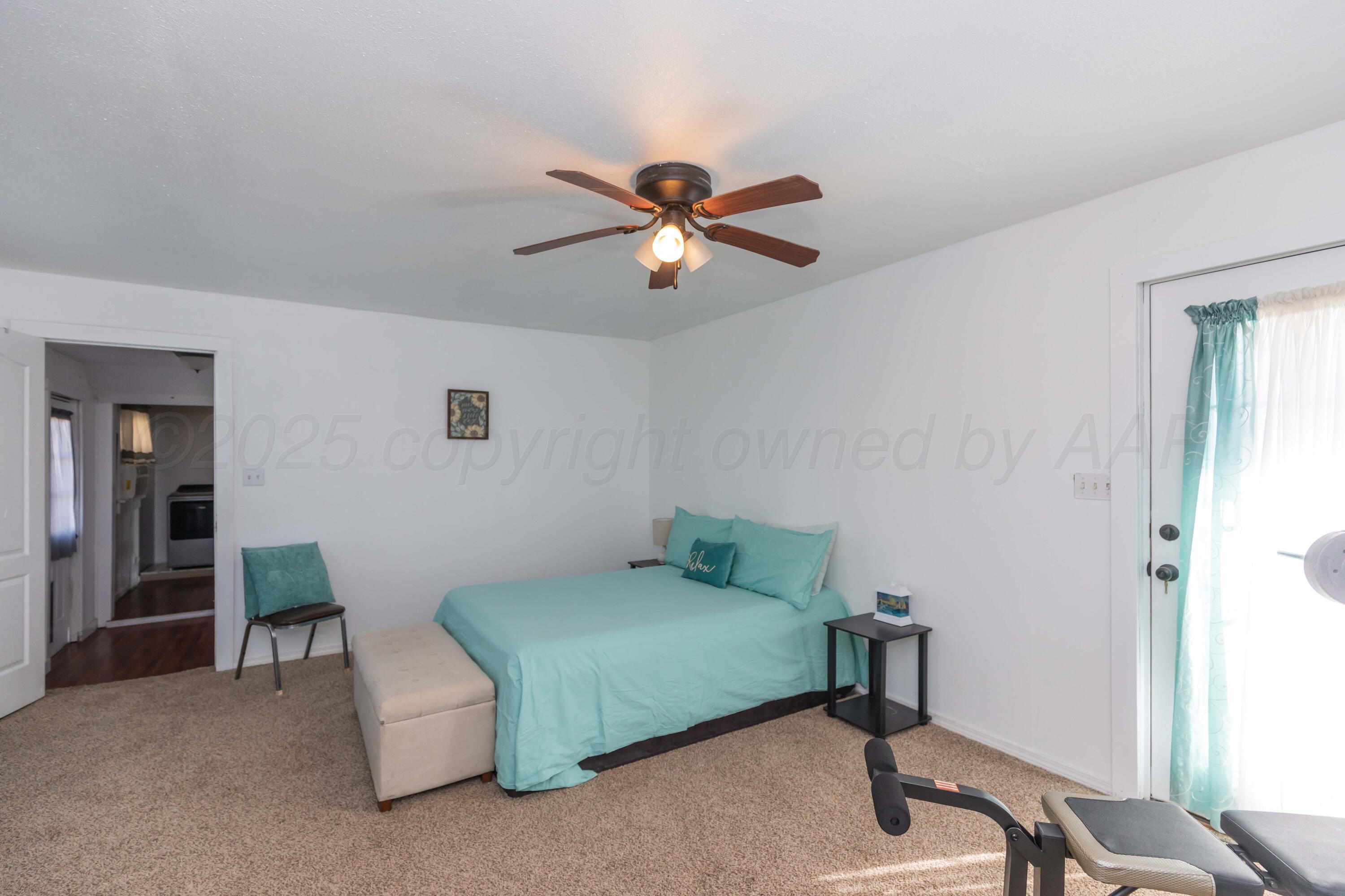 105 Poplar Street Skellytown, TX 79080 - Photo 17 of 37 a bedroom with a bed and a chandelier fan