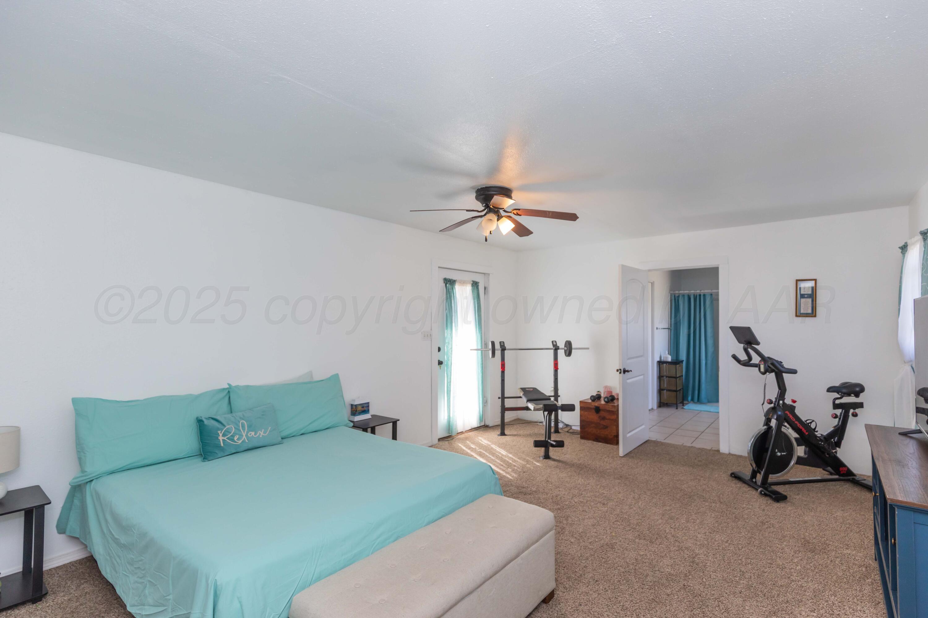 105 Poplar Street Skellytown, TX 79080 - Photo 19 of 37 a bed room with a bed furniture and a chandelier