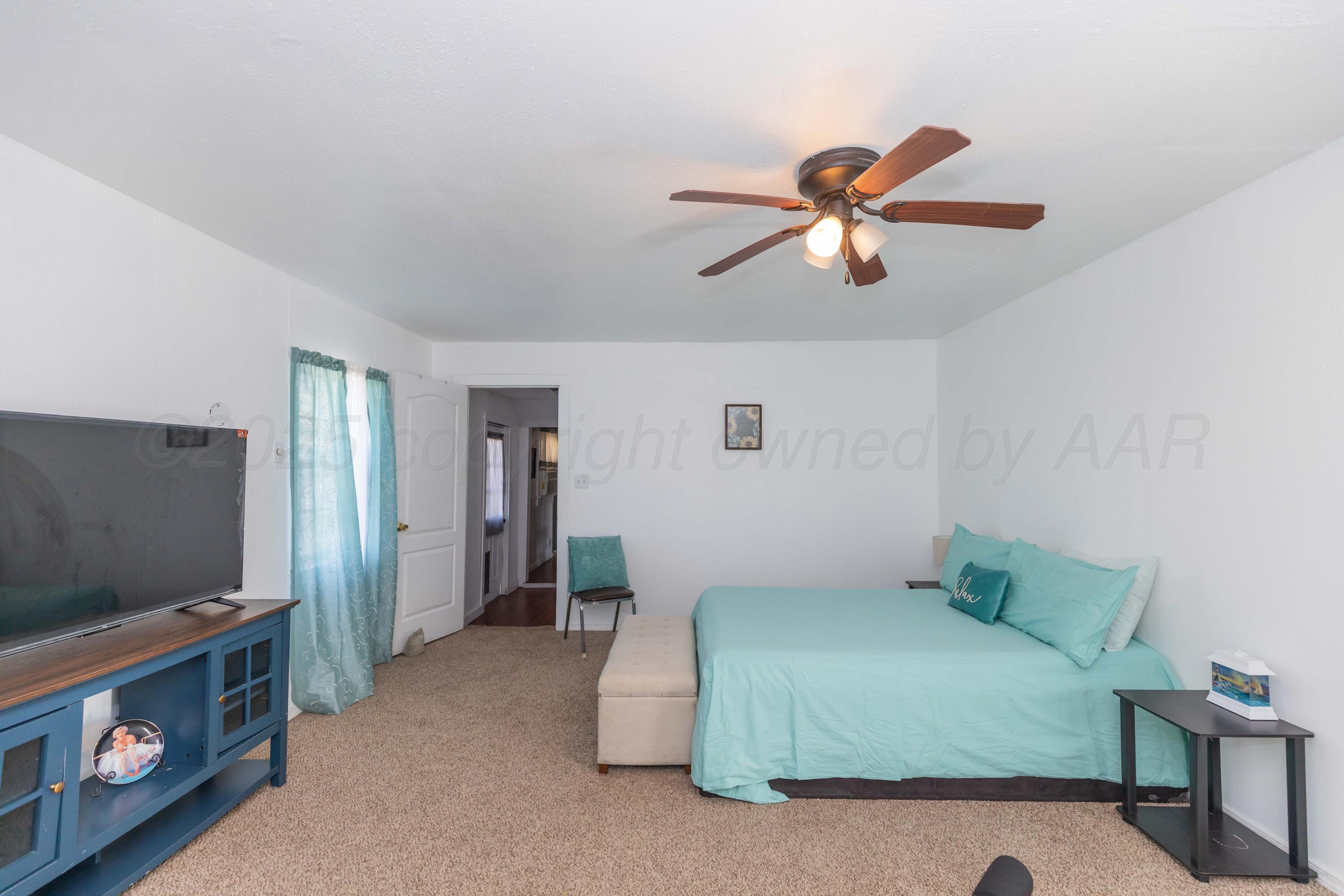 105 Poplar Street Skellytown, TX 79080 - Photo 20 of 37 a bedroom with a bed and a flat screen tv