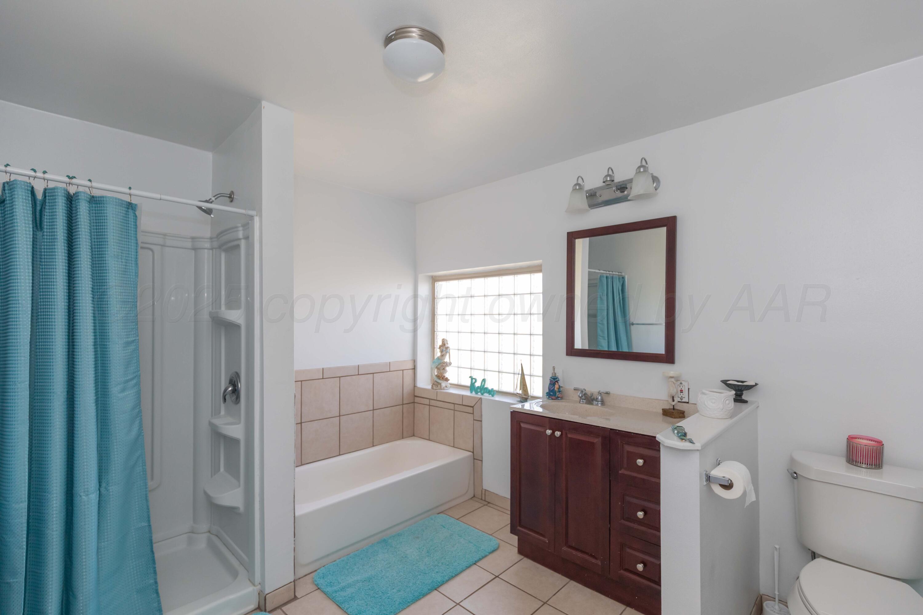 105 Poplar Street Skellytown, TX 79080 - Photo 23 of 37 a bathroom with a tub sink toilet and mirror