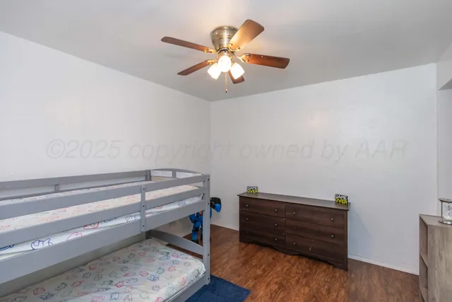 a view of room with wooden floor and ceiling fan