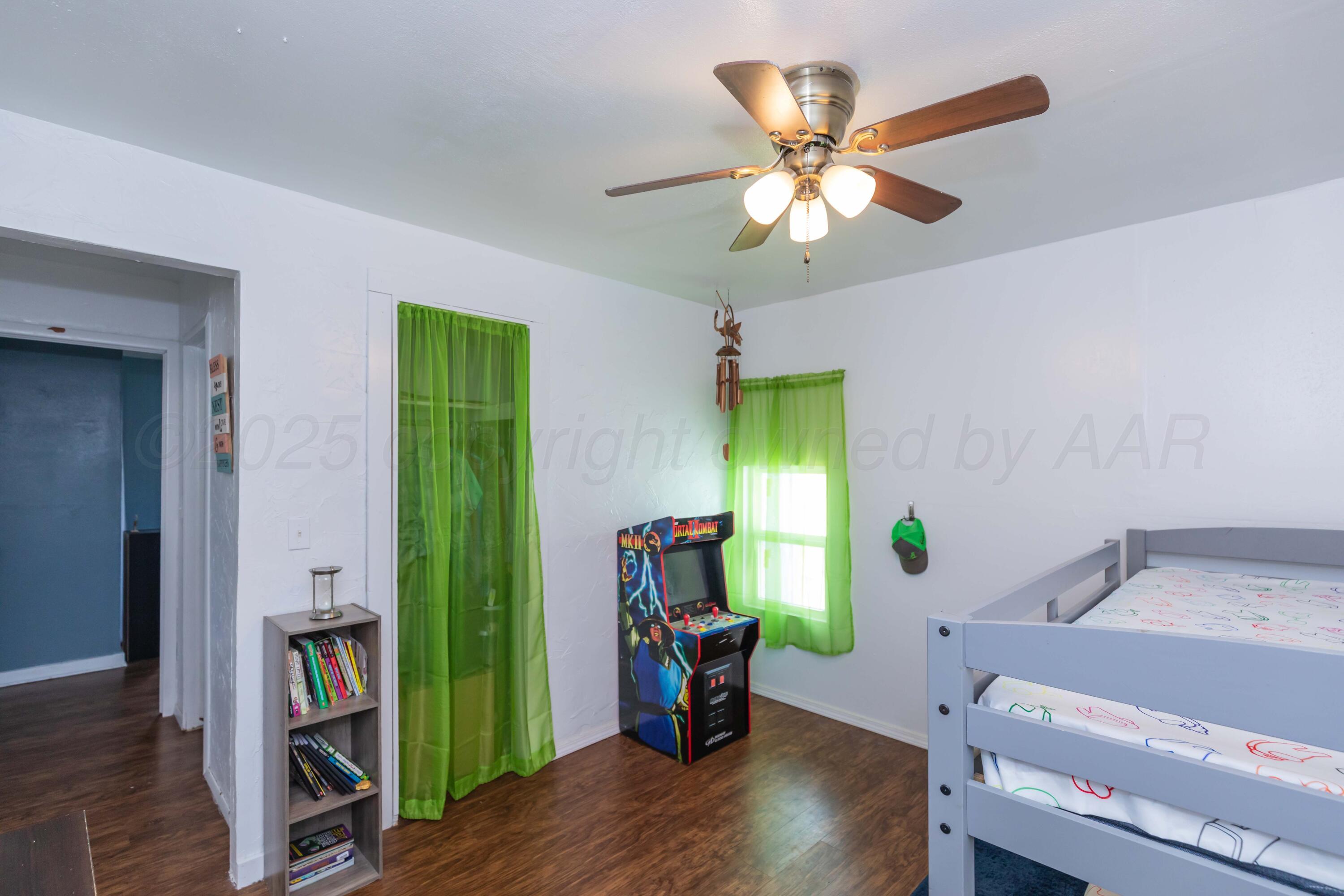 105 Poplar Street Skellytown, TX 79080 - Photo 26 of 37 a view of an empty room with wooden floor and a ceiling fan