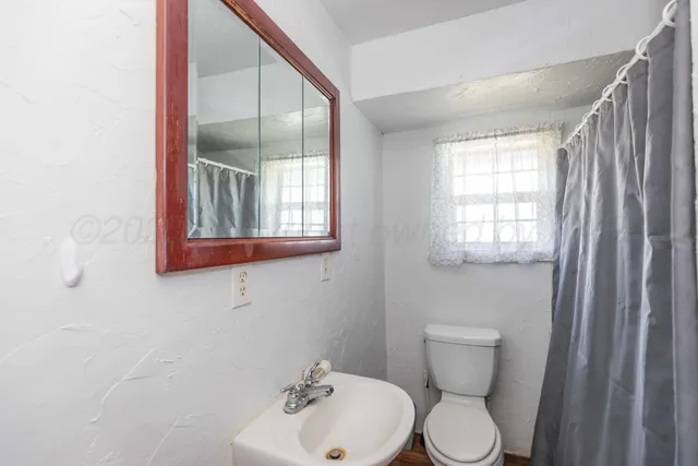 a bathroom with a toilet sink and mirror