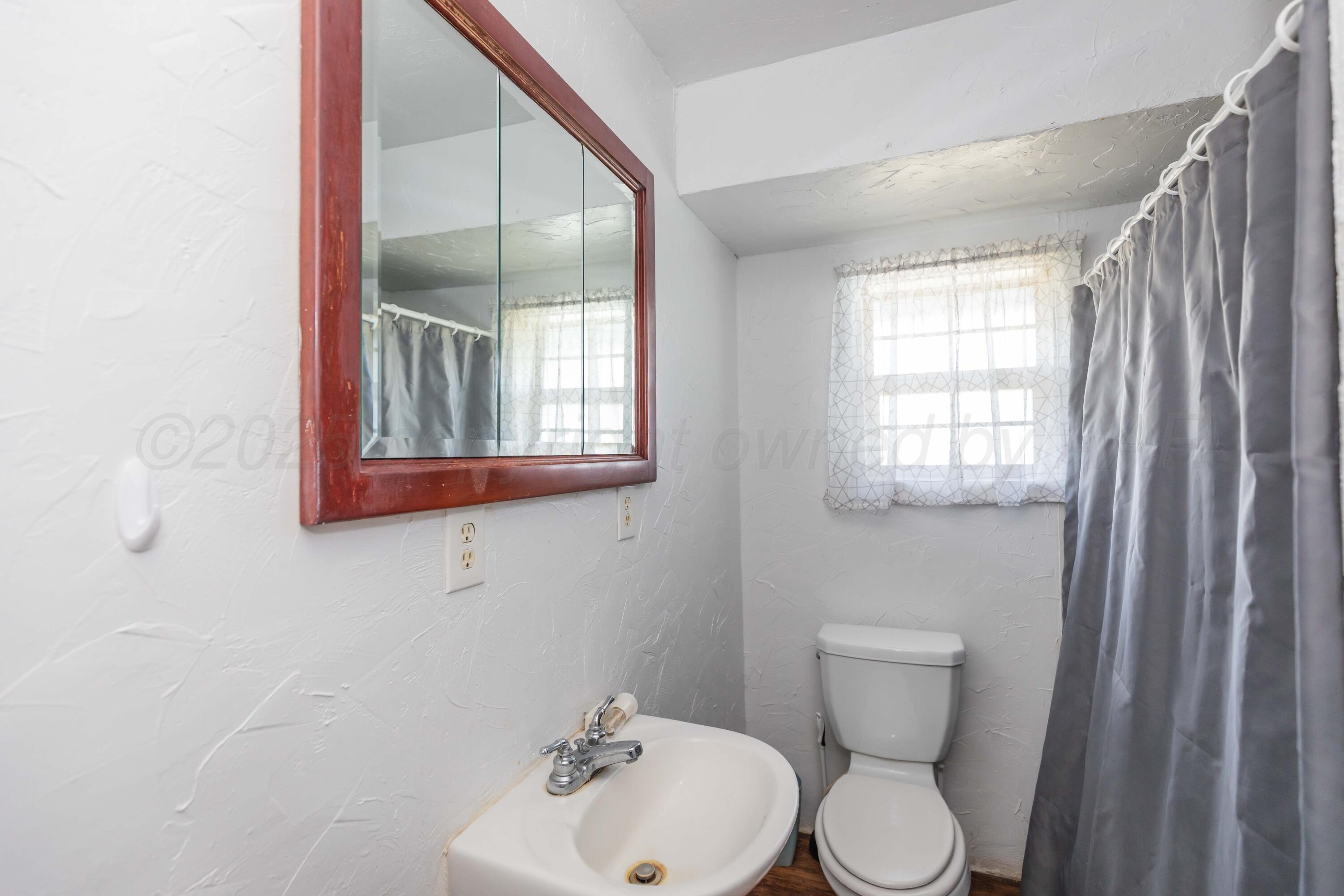 105 Poplar Street Skellytown, TX 79080 - Photo 28 of 37 a bathroom with a toilet sink and mirror