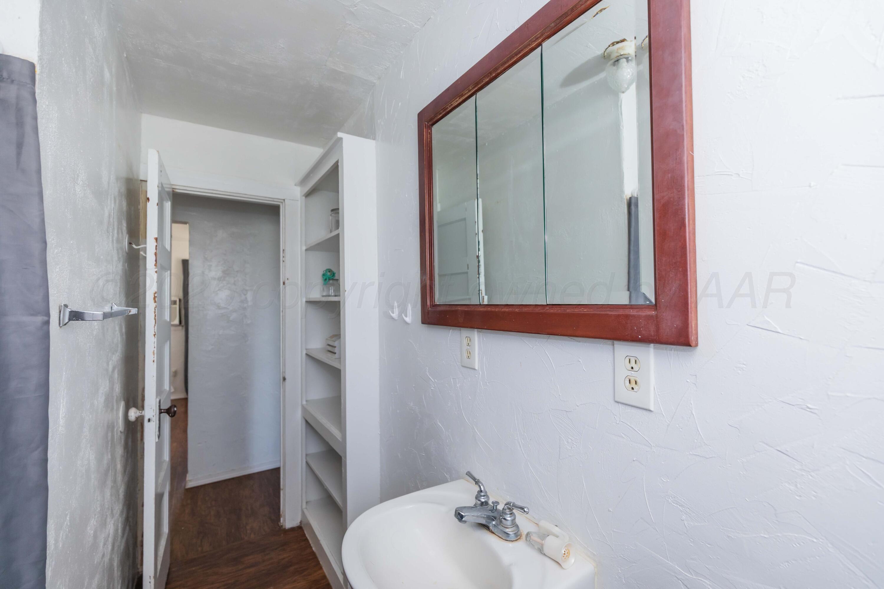 105 Poplar Street Skellytown, TX 79080 - Photo 29 of 37 a bathroom with a sink and a mirror