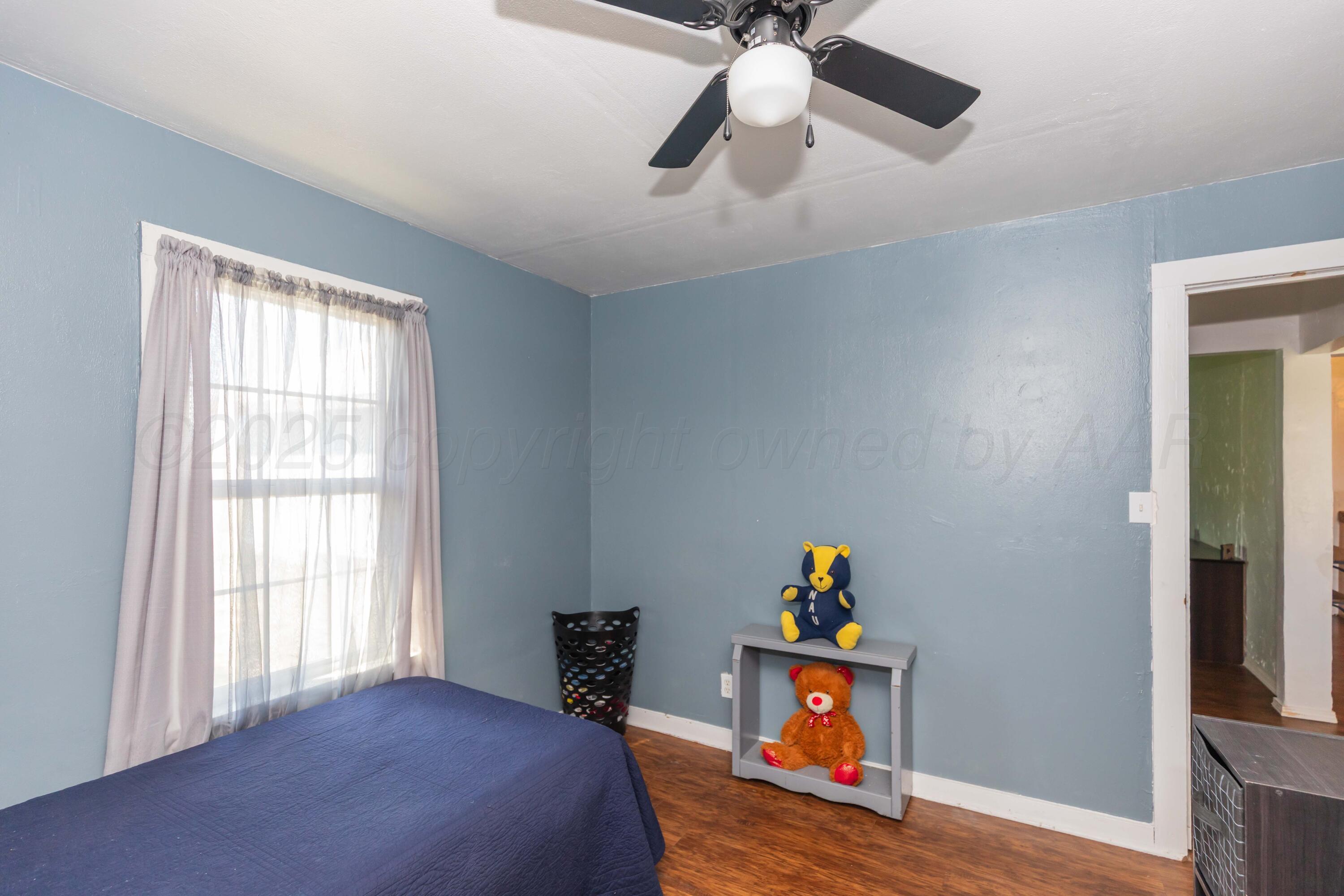 105 Poplar Street Skellytown, TX 79080 - Photo 32 of 37 a bedroom with a bed and a chandelier