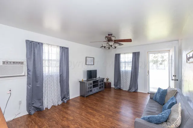 a living room with furniture and wooden floor