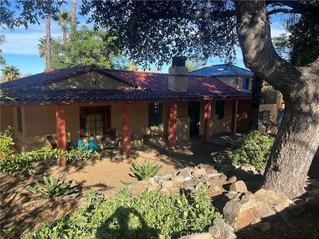 a front view of a house with a yard and a garden