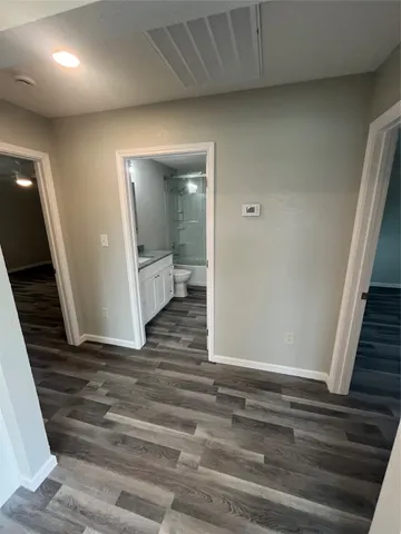 a view of a hallway with wooden floor and staircase