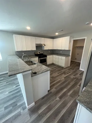 a kitchen with stainless steel appliances granite countertop a sink stove and cabinets