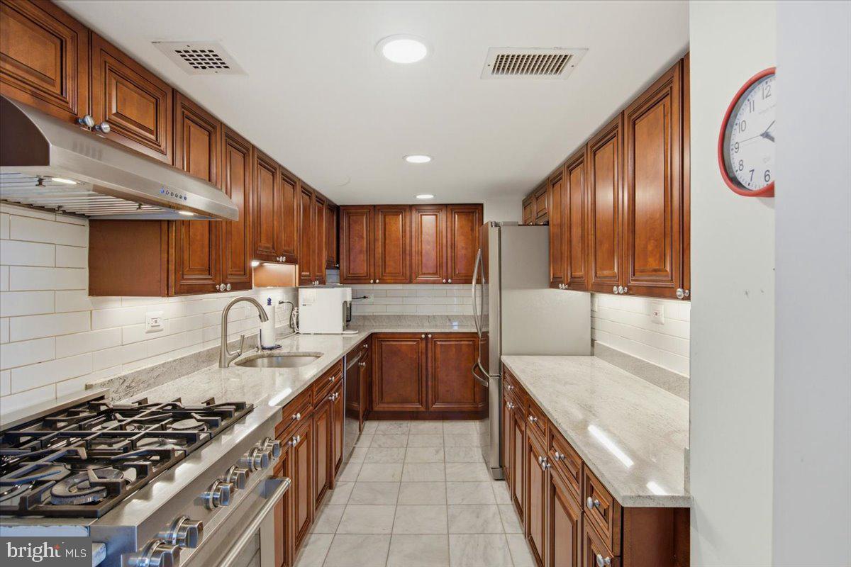 700 7th Street Southwest, Unit 827 Washington, DC 20024 - Photo 20 of 32 Elegant kitchen with rich wood cabinetry.