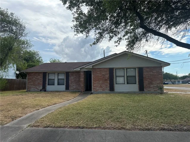 a front view of a house with yard and trees