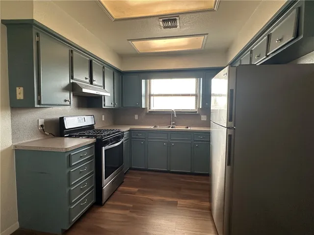 a kitchen with stainless steel appliances granite countertop a sink stove and refrigerator