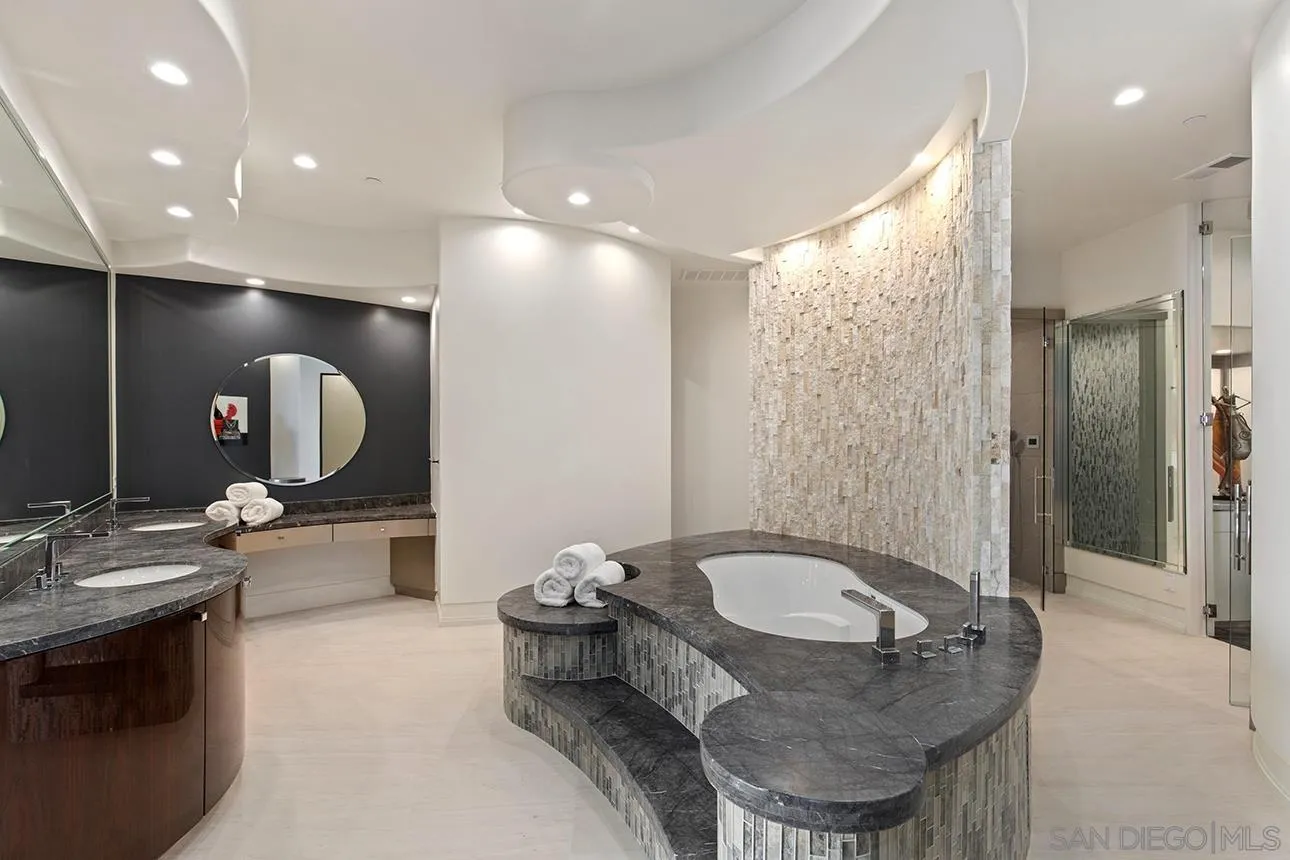 7447 Hillside Drive La Jolla, CA 92037 - Photo 22 of 55 a bathroom with a granite countertop sink a mirror and a shower