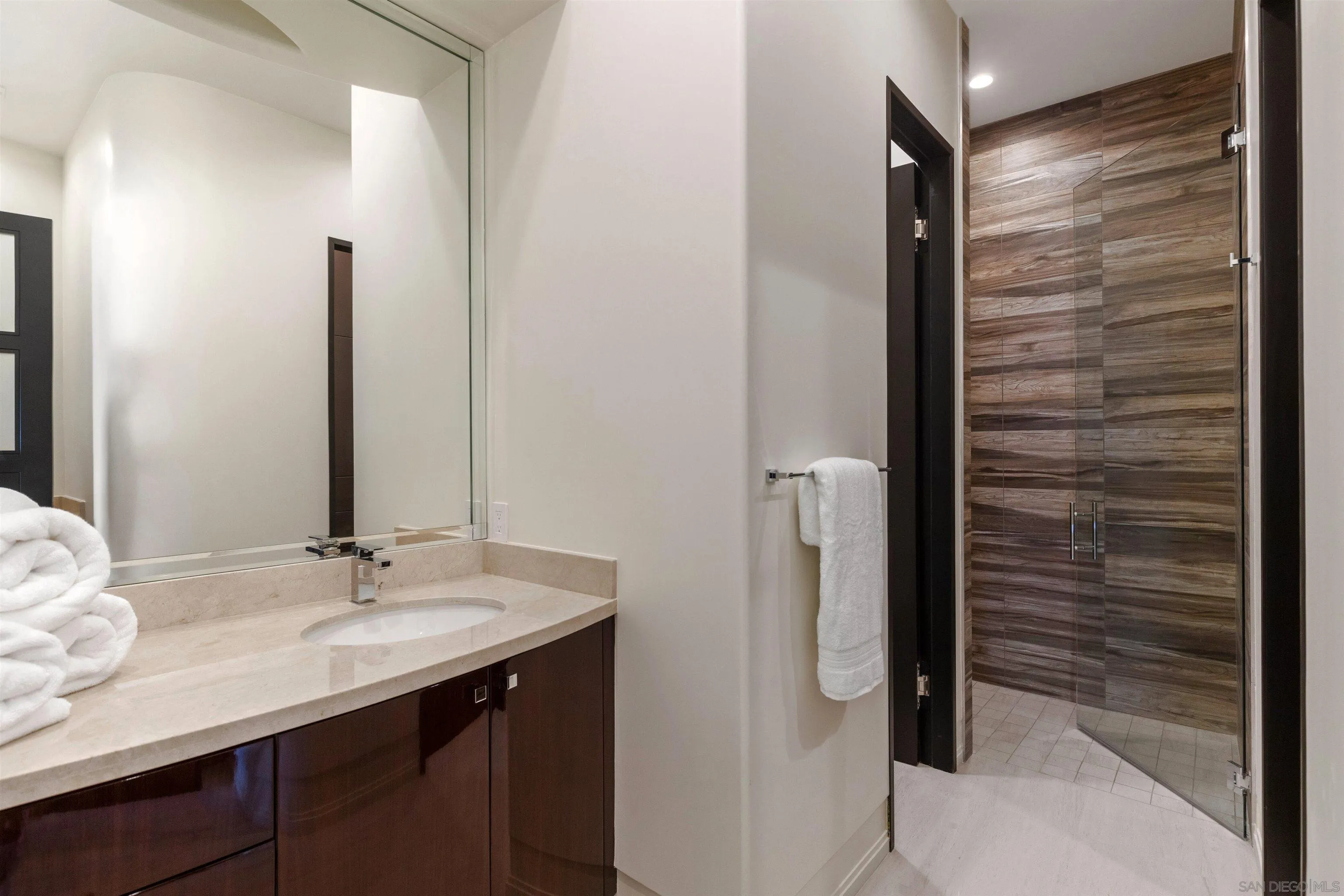 7447 Hillside Drive La Jolla, CA 92037 - Photo 27 of 55 a bathroom with a shower sink and mirror
