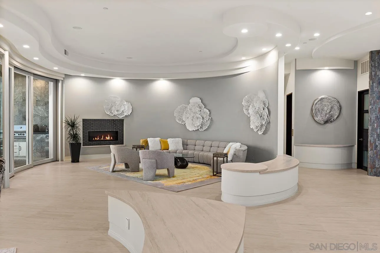 7447 Hillside Drive La Jolla, CA 92037 - Photo 50 of 55 a living room with furniture a mirror and a fireplace