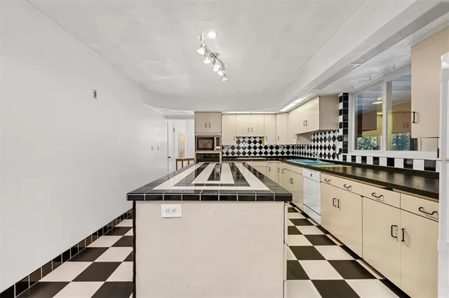 a kitchen with granite countertop stainless steel appliances a sink and cabinets