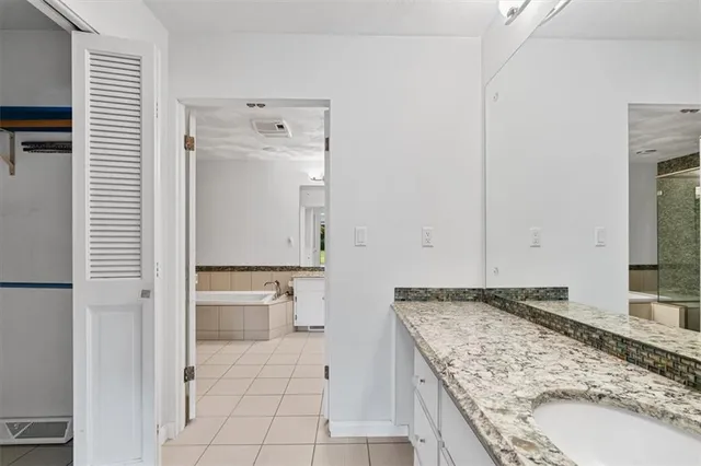 a bathroom with a granite countertop sink and a mirror
