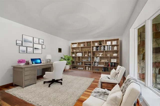 a living room with furniture a rug and a bookshelf