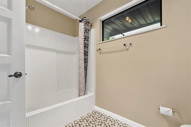 a bathroom with a window and a shower