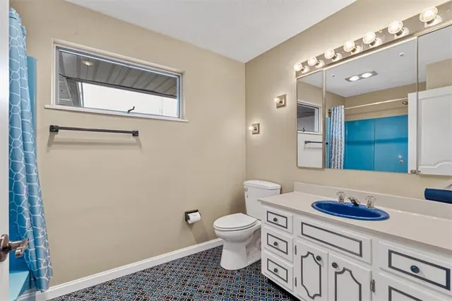 a bathroom with a sink a toilet and a mirror