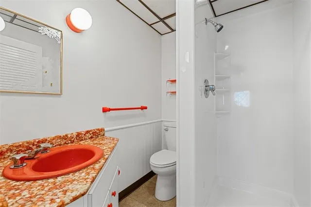 a bathroom with a granite countertop sink toilet and shower