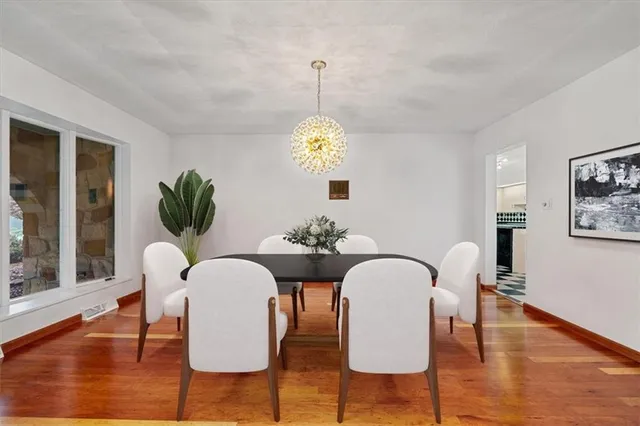 a dining room with furniture a chandelier and wooden floor