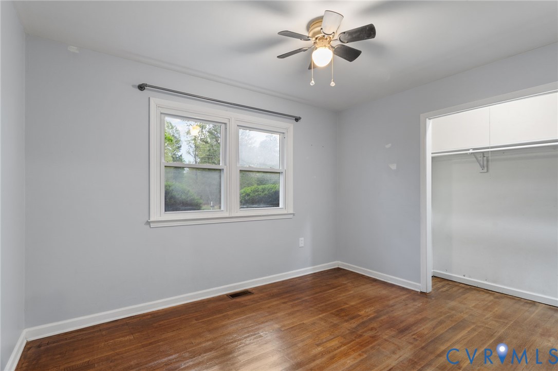 8141 Military Road Amelia Court House, VA 23002 - Photo 22 of 40 an empty room with wooden floor chandelier fan and windows