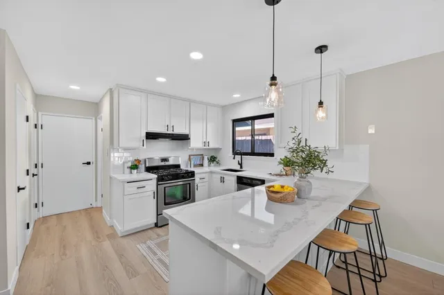 a kitchen with a sink a stove and chairs