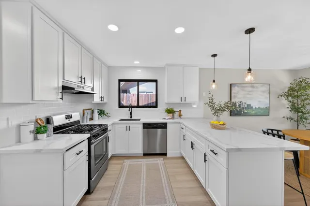 a kitchen with white cabinets stainless steel appliances and sink